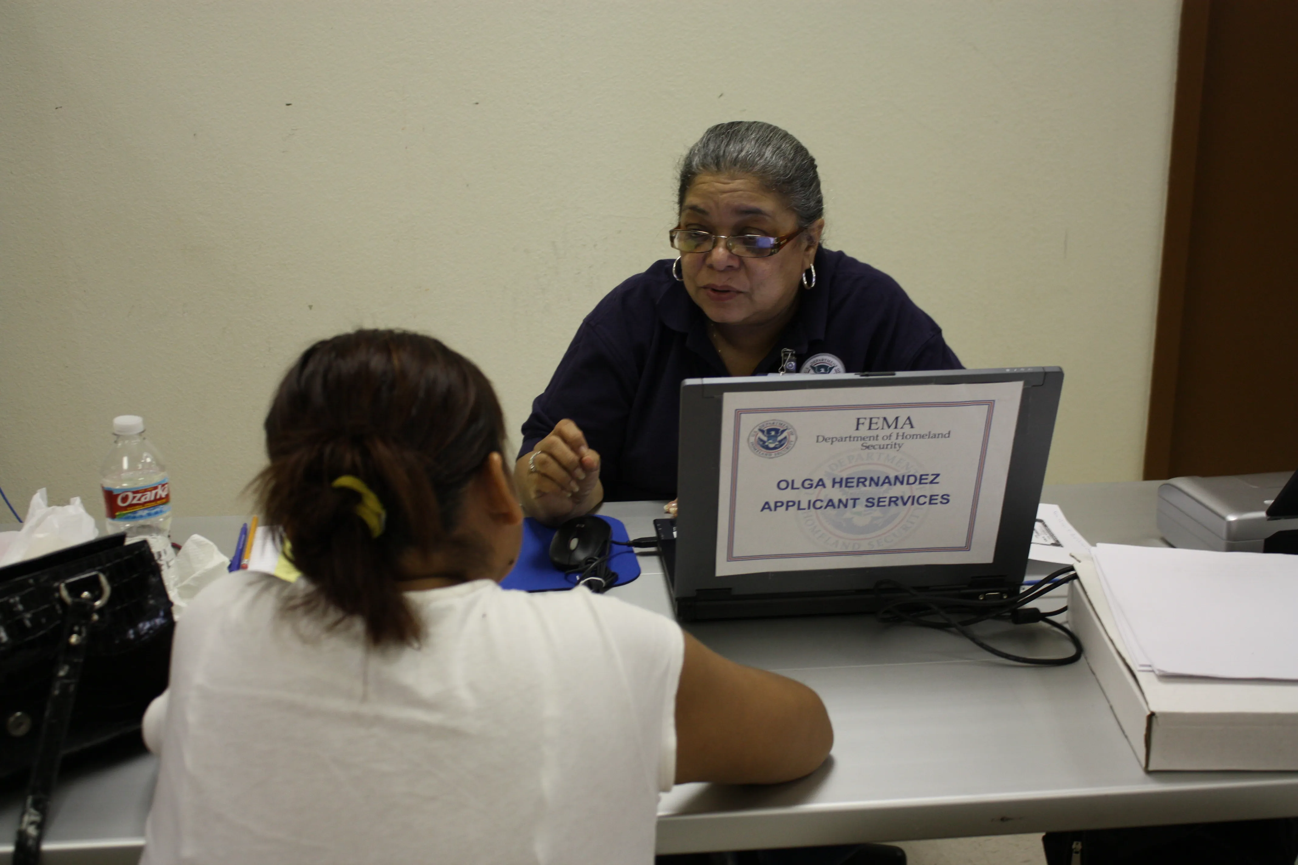 Survivors meeting with aid representatives at desks inside a disaster recovery center