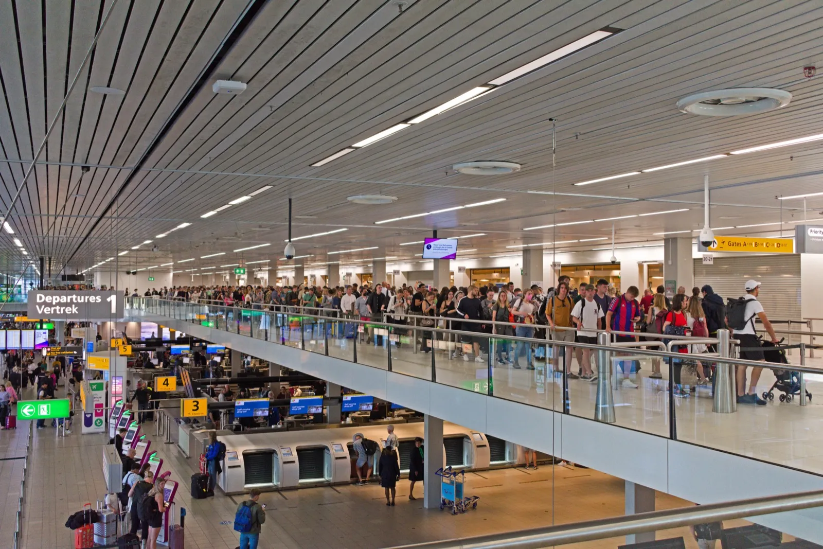 A long queue of travelers with luggage at an airport terminal
