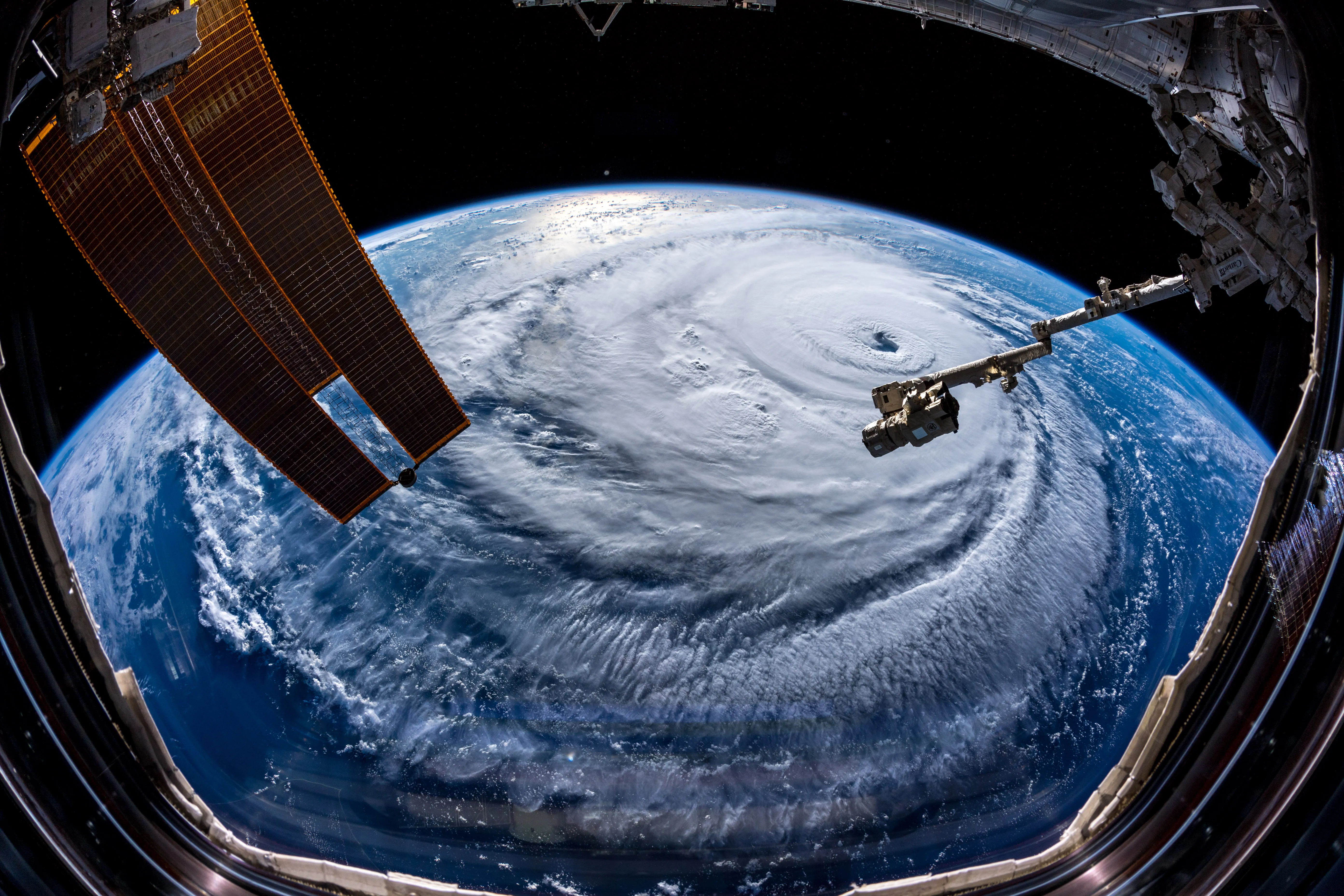 A close astronaut view of a hurricane's eye and the towering ring of cloud forming its eyewall