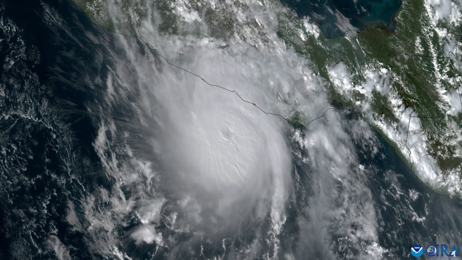A satellite image of Hurricane Otis intensifying explosively into a compact, powerful storm near Mexico's Pacific coast