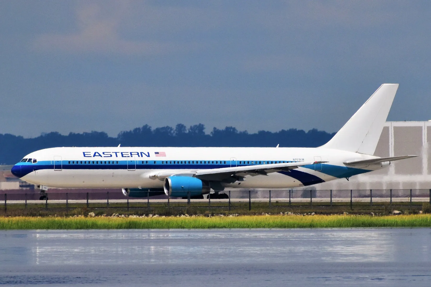 A twin-engine Boeing 767 airliner taxis along a runway at JFK Airport