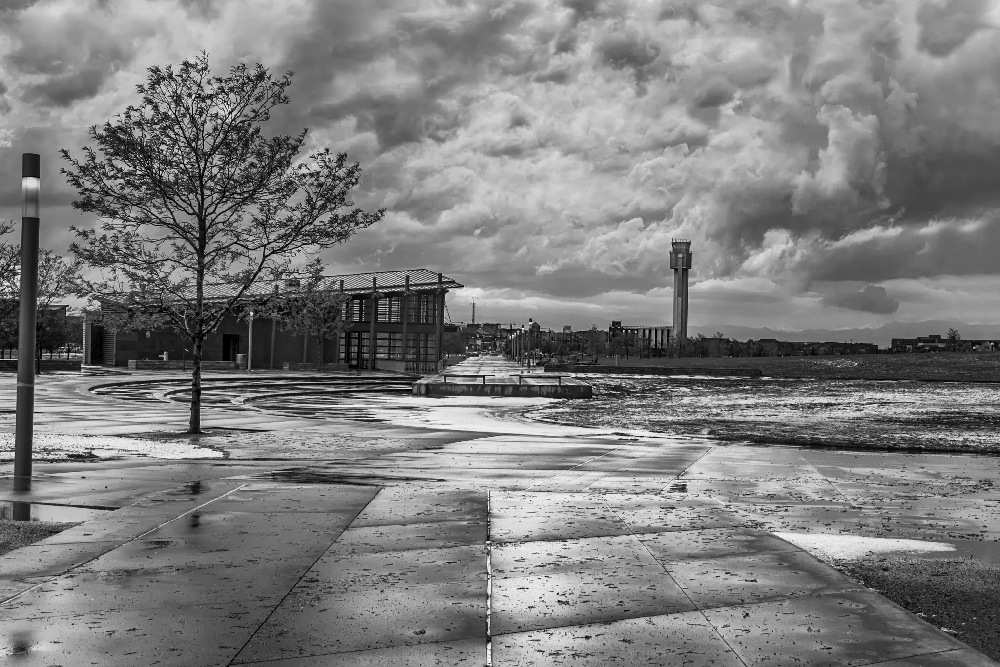 An airport control tower beneath a churning storm sky