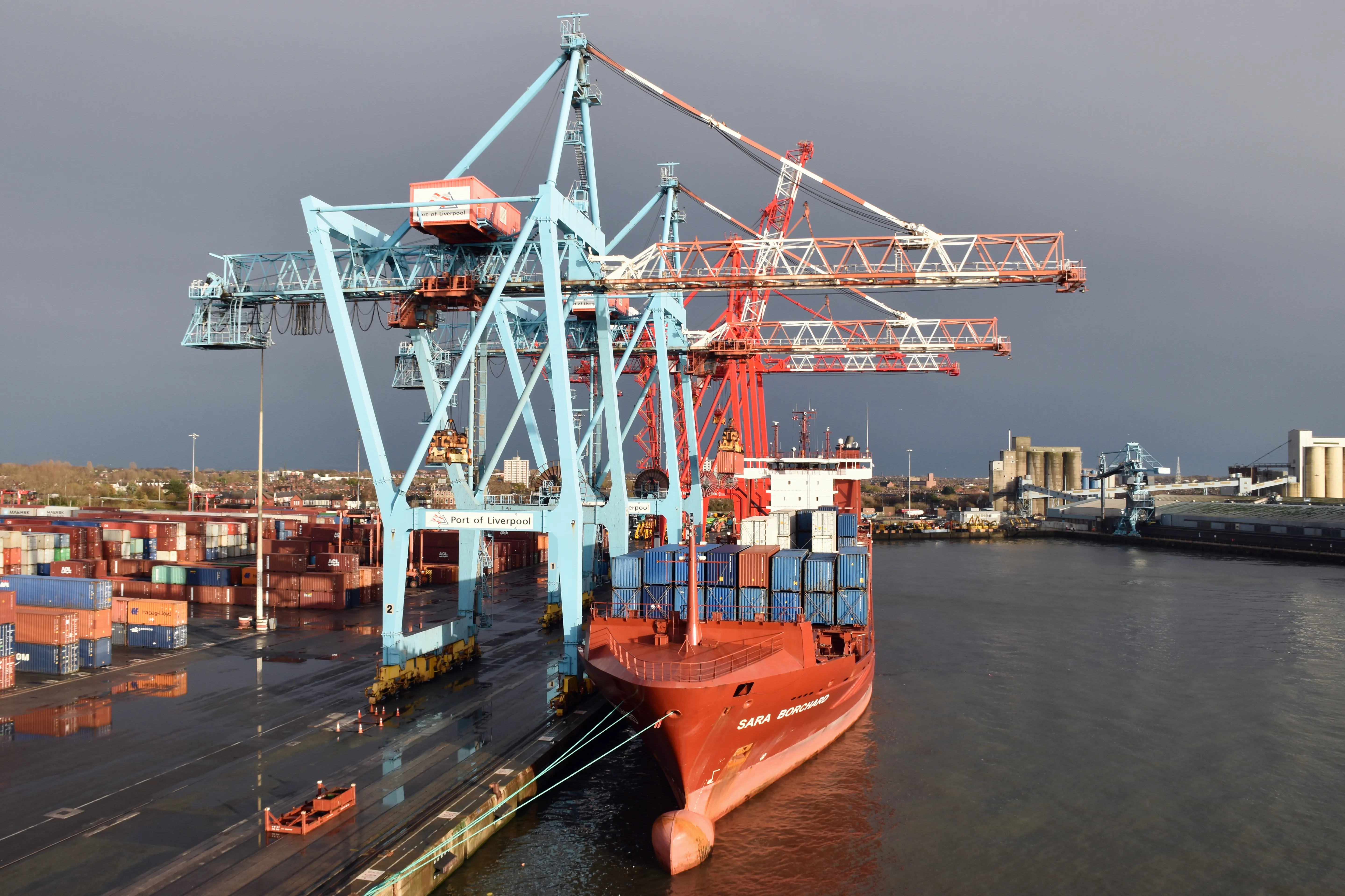 Gantry cranes and stacked shipping containers at a busy container port terminal