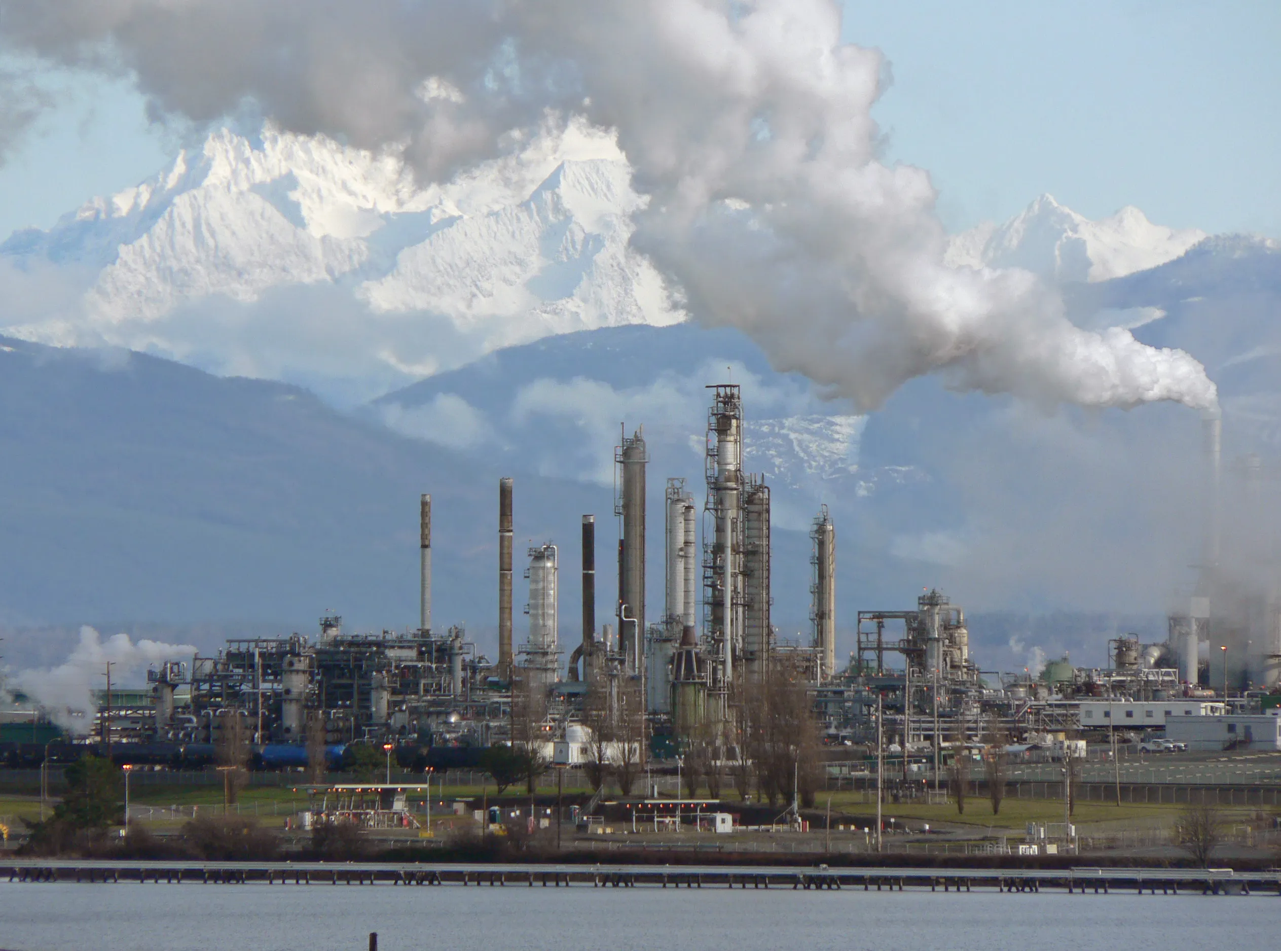 A large petroleum refinery with towers and steam plumes, the kind of energy infrastructure hurricanes can knock offline
