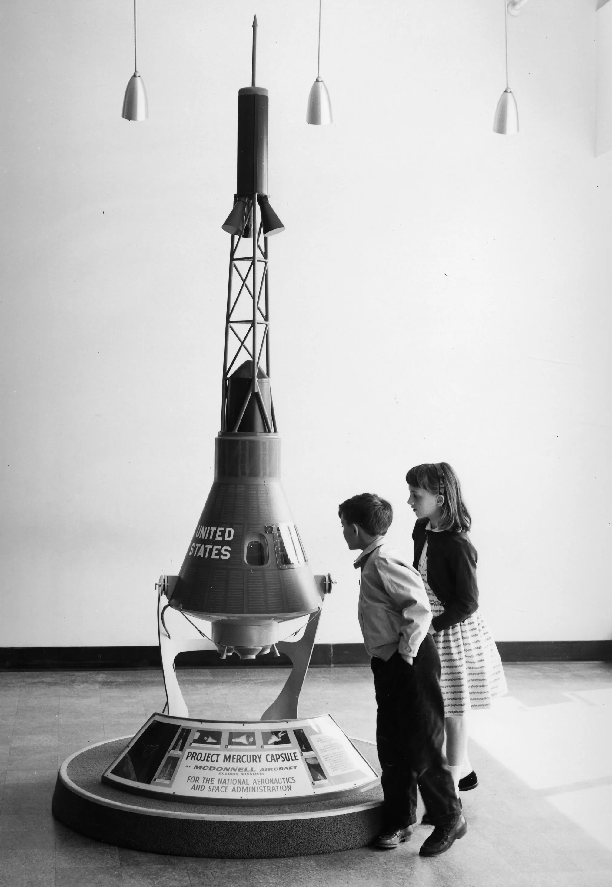 Two children study a model spacecraft on display at the National Air Museum