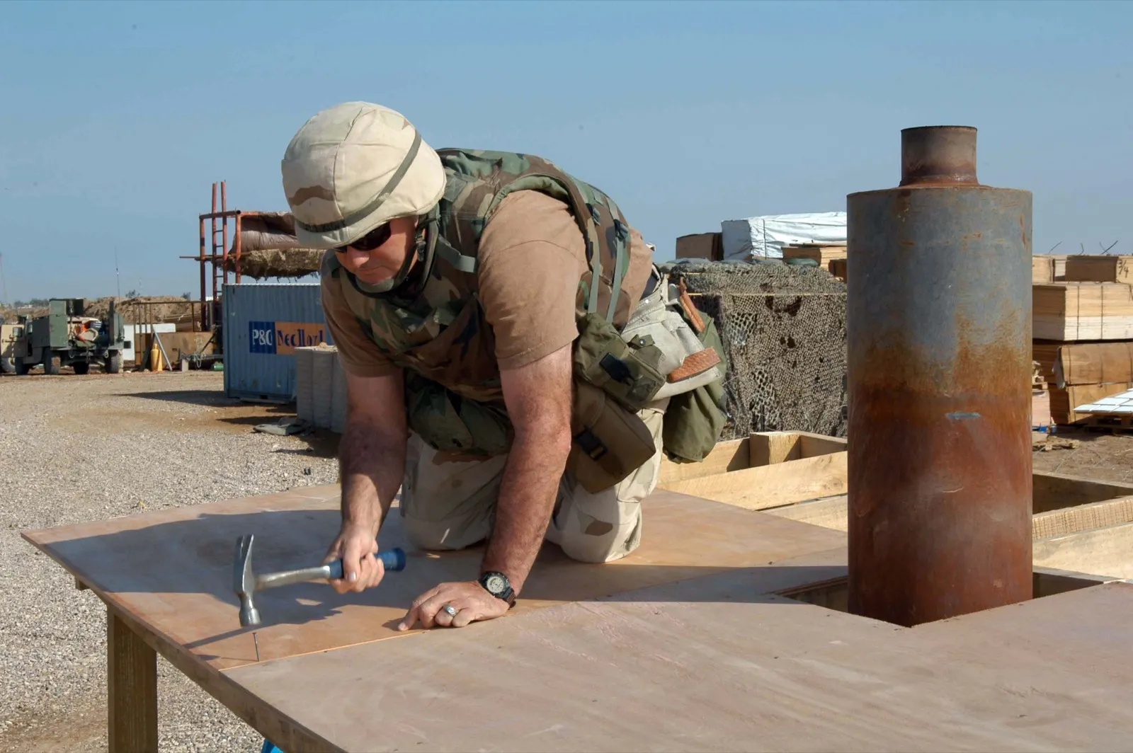 A worker nailing plywood roof sheathing to roof framing