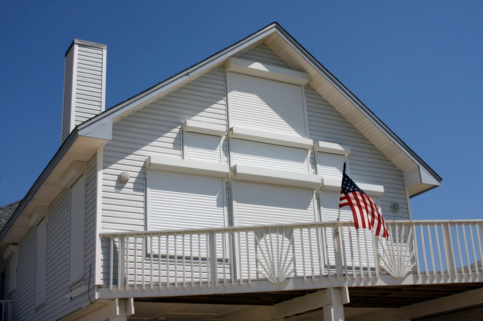 Rolling storm shutters closed over the windows of a coastal home