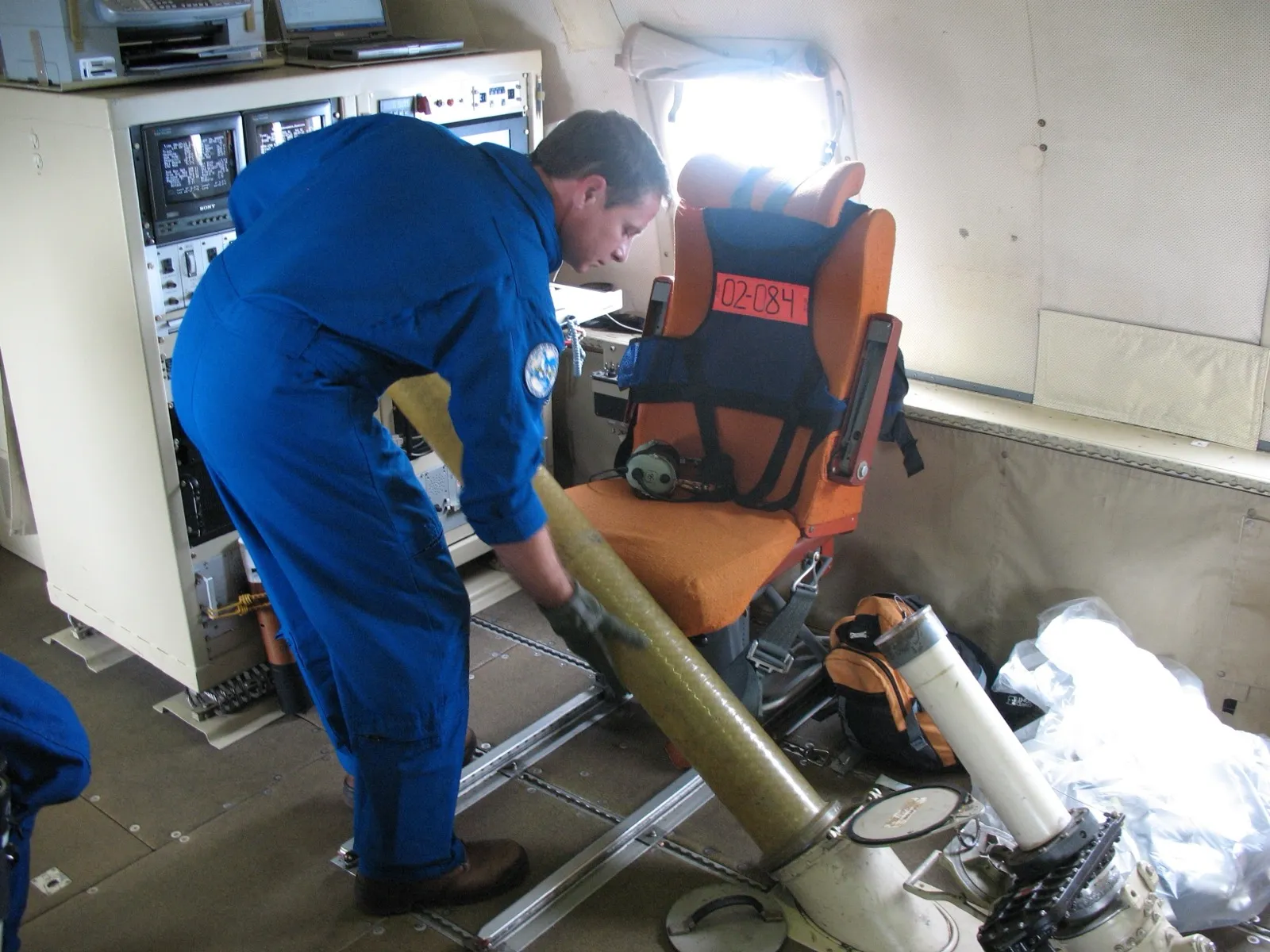 A NOAA crew member loading a dropsonde aboard a Hurricane Hunter aircraft