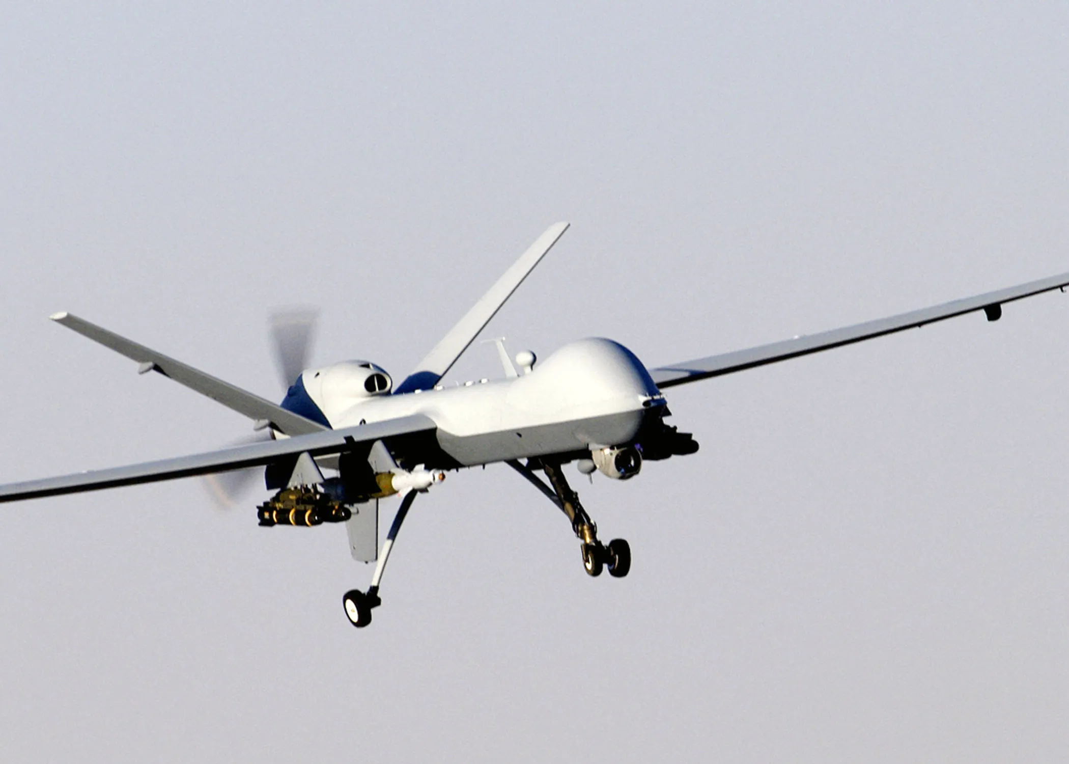 A large MQ-9 Reaper uncrewed aircraft in flight against a clear sky