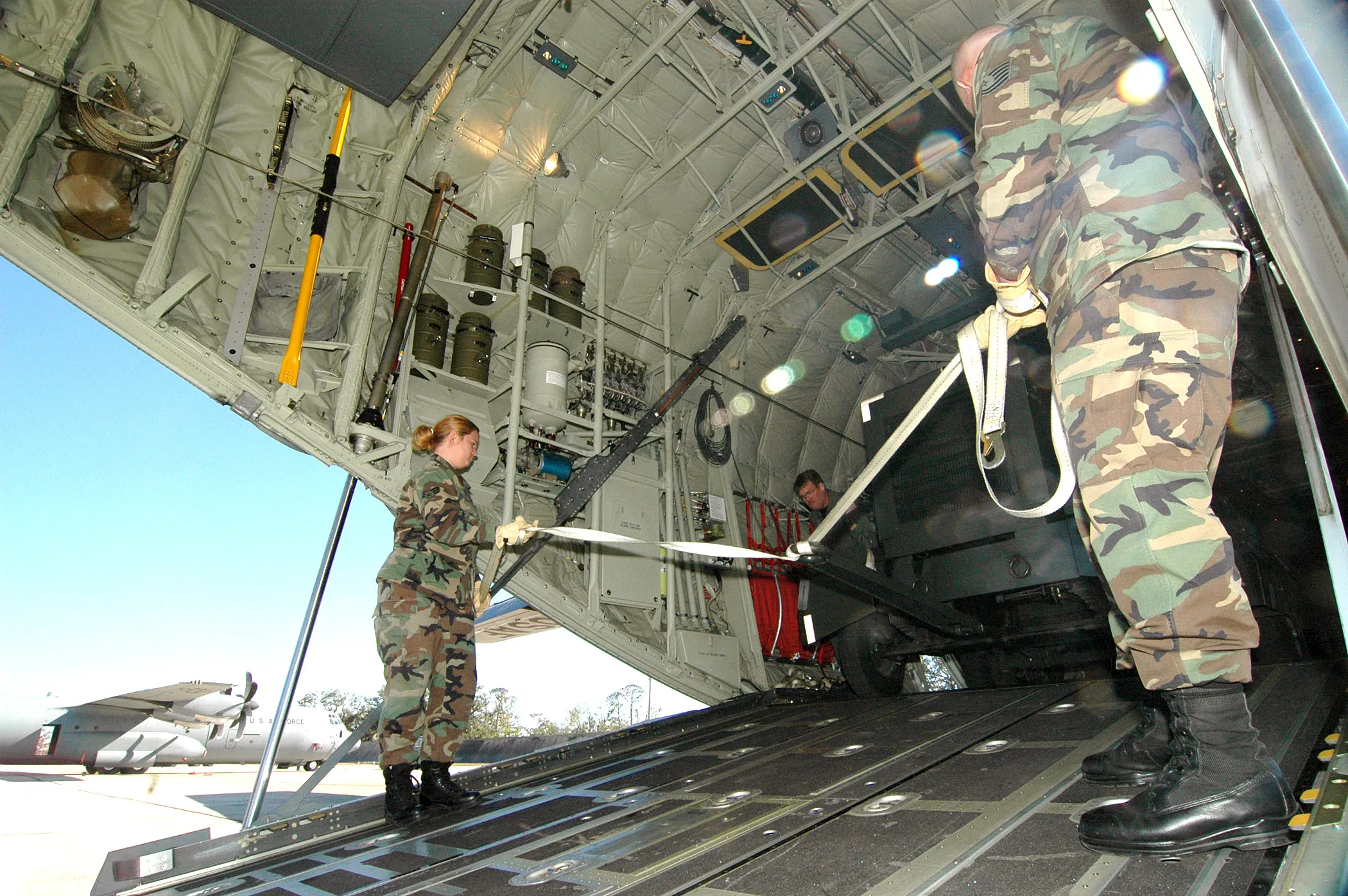 Aircrew load equipment aboard a WC-130J in the cargo bay