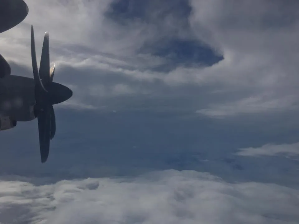 A WC-130J turboprop engine and propeller silhouetted against the towering clouds of a hurricane