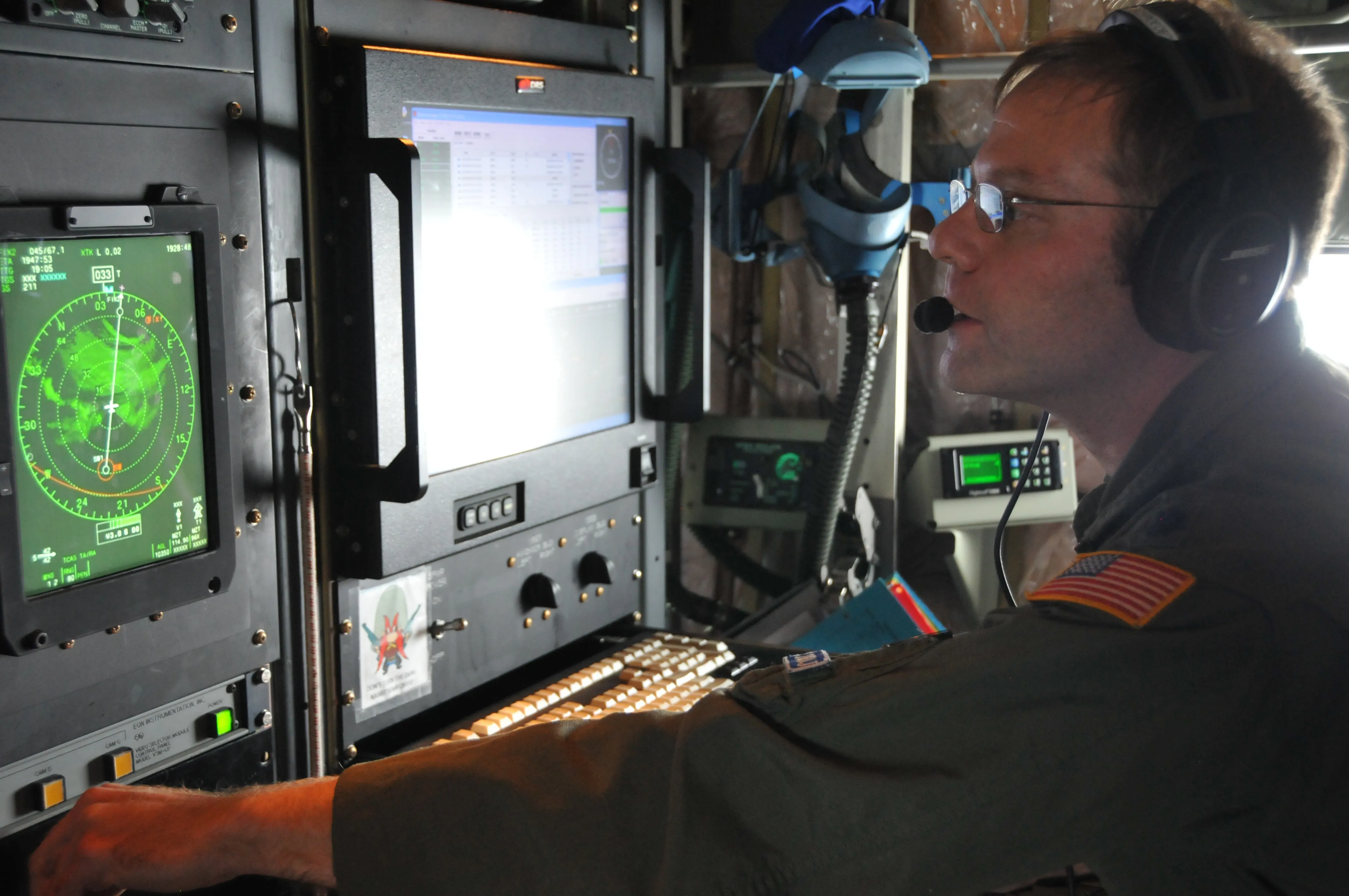 An aerial reconnaissance weather officer studies a radar scope at a console aboard a WC-130J