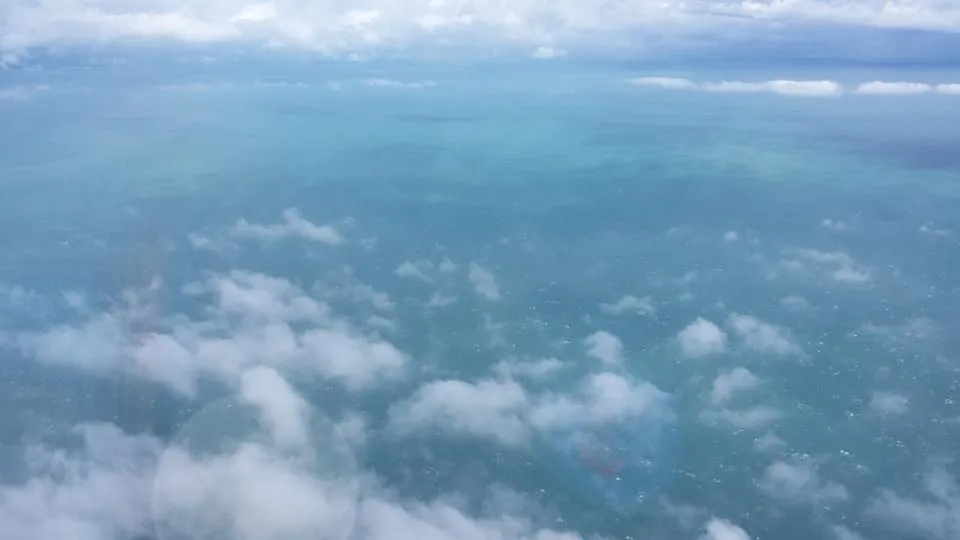 The disorganized cloud field and ocean surface of a tropical storm seen from a reconnaissance aircraft