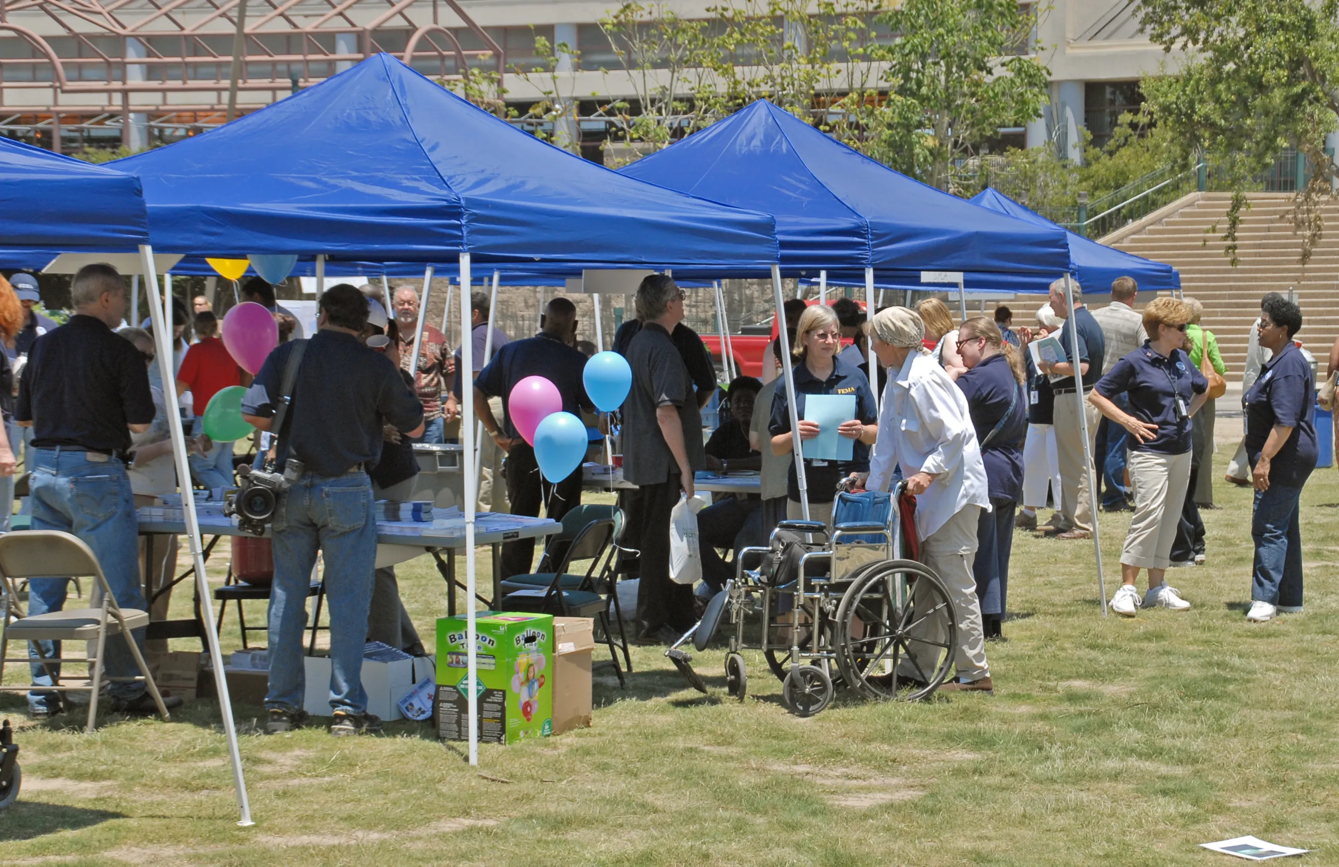 Families gather at a community hurricane preparedness event with information tents