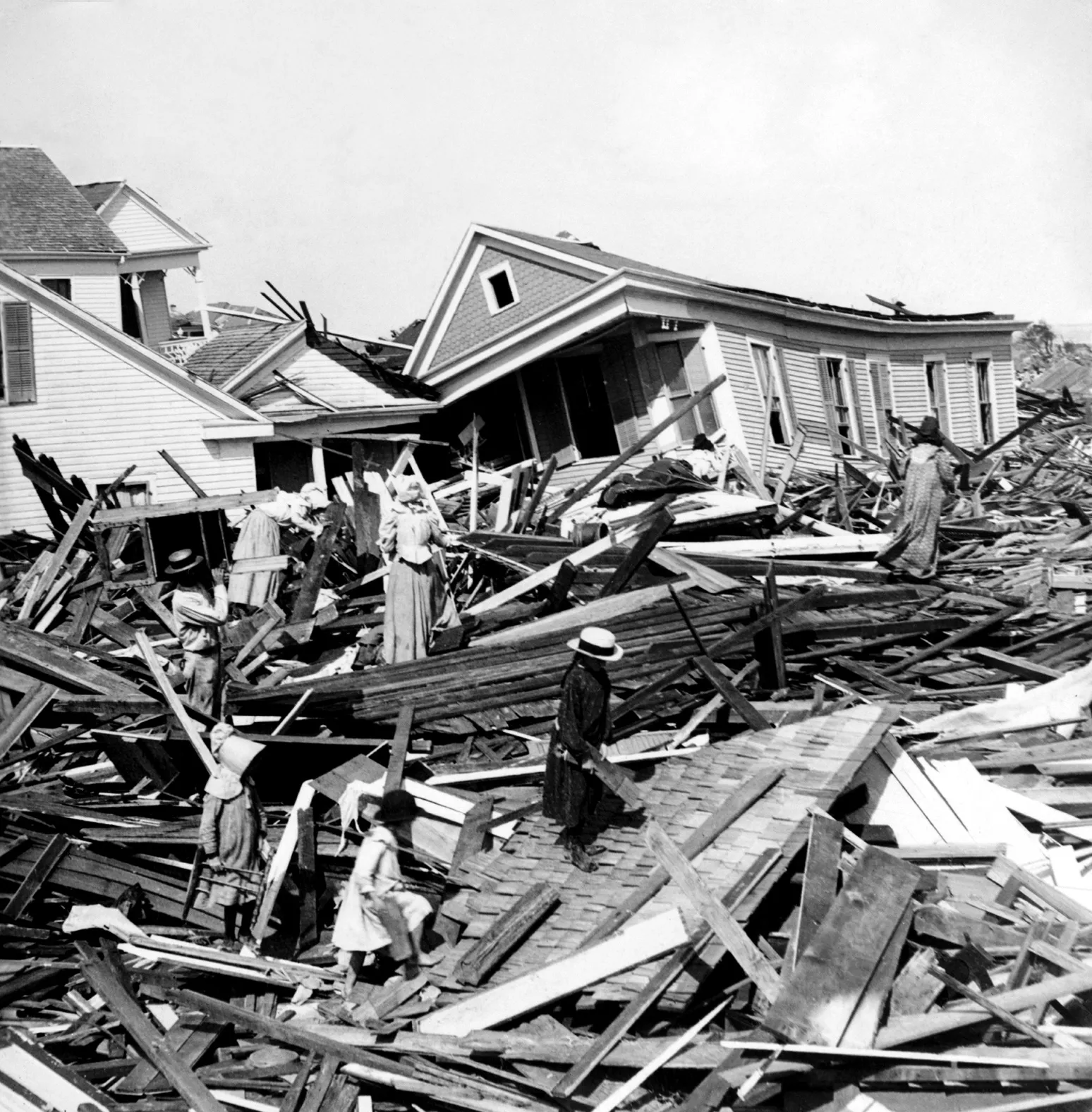 People searching through the splintered wreckage of homes after the 1900 Galveston hurricane
