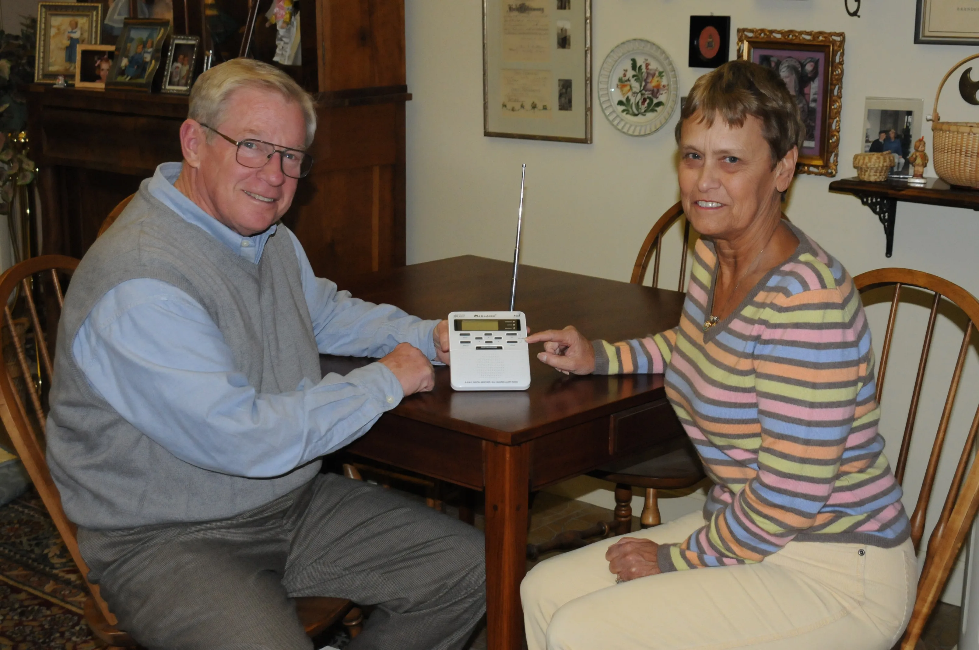 Two people listening to a NOAA Weather Radio at home