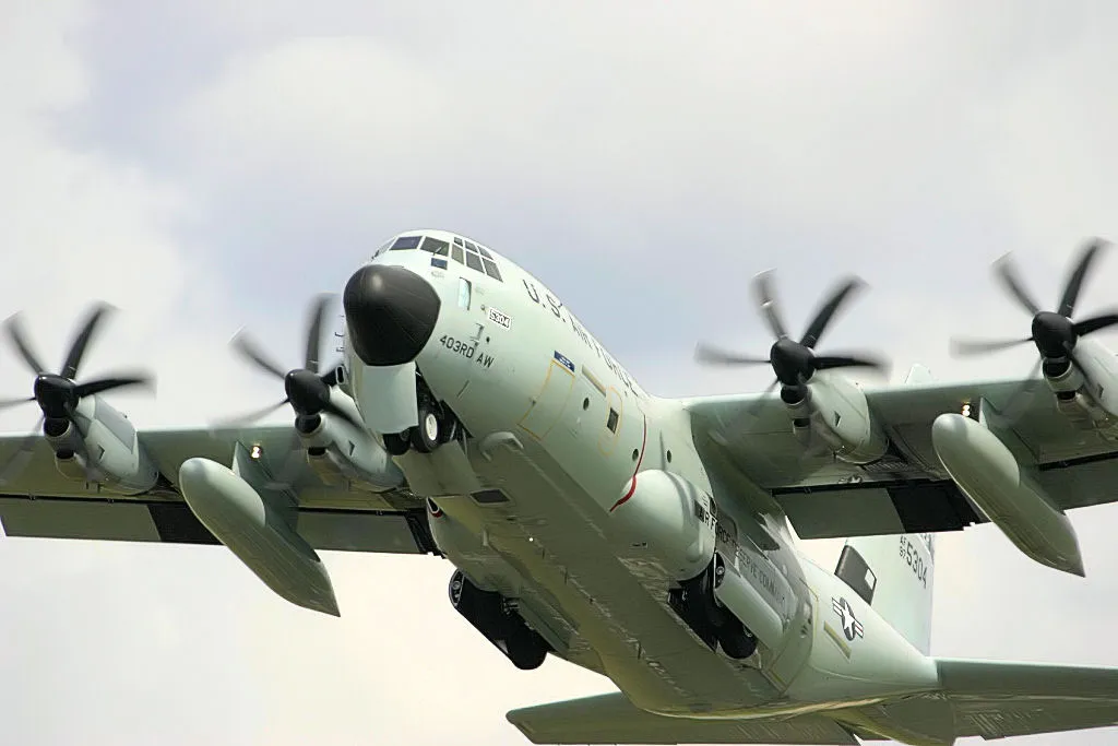An Air Force Reserve WC-130J Hurricane Hunter aircraft flying with its landing gear down