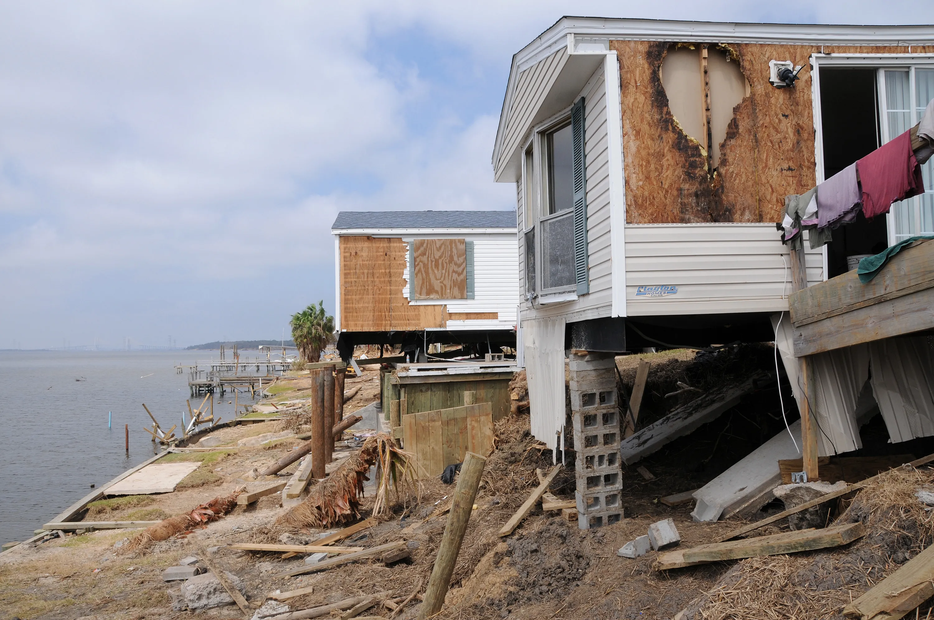 Waterfront homes torn open and undermined by storm surge after a hurricane