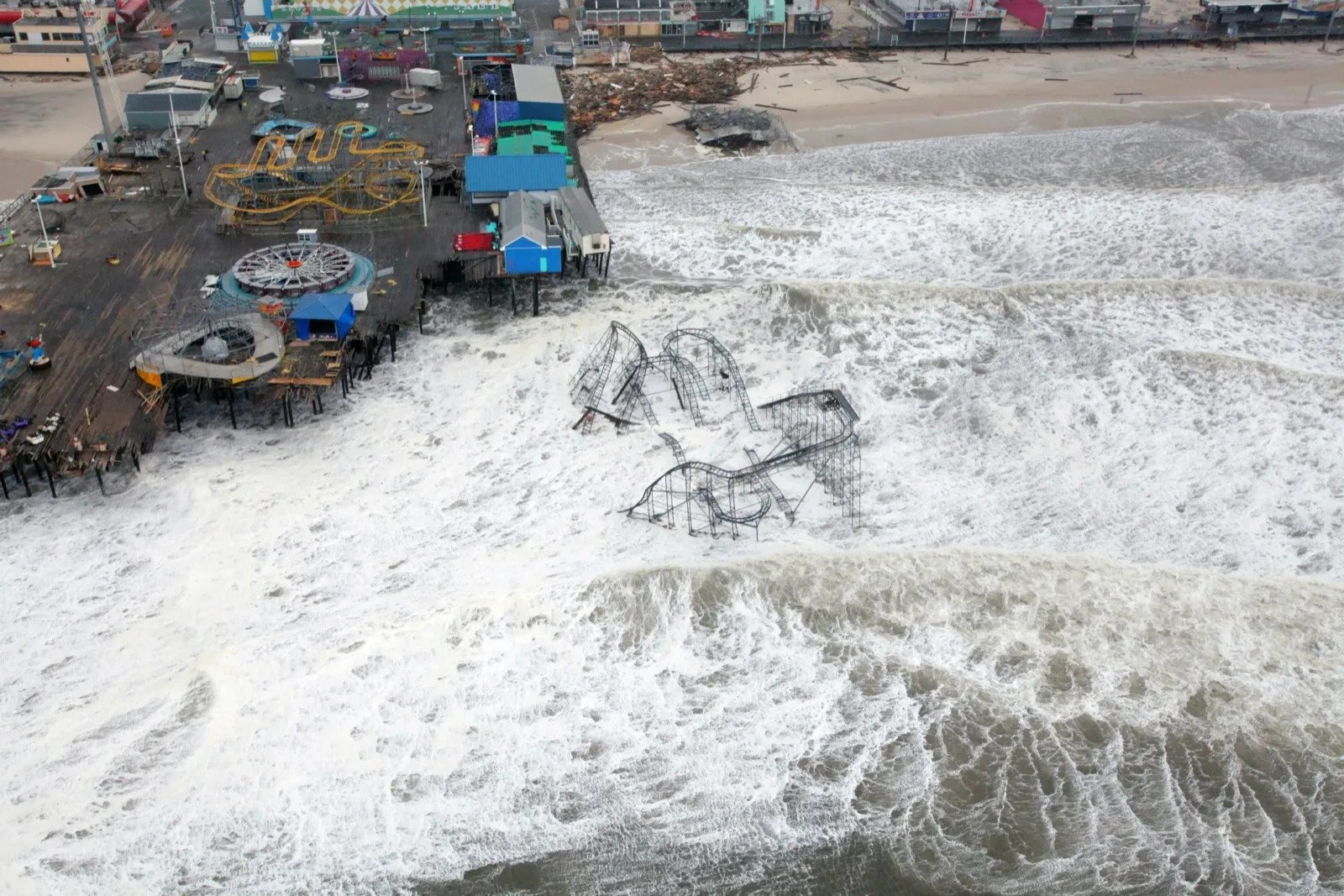 Aerial view of the Seaside Heights amusement pier with the Star Jet roller coaster collapsed into the ocean