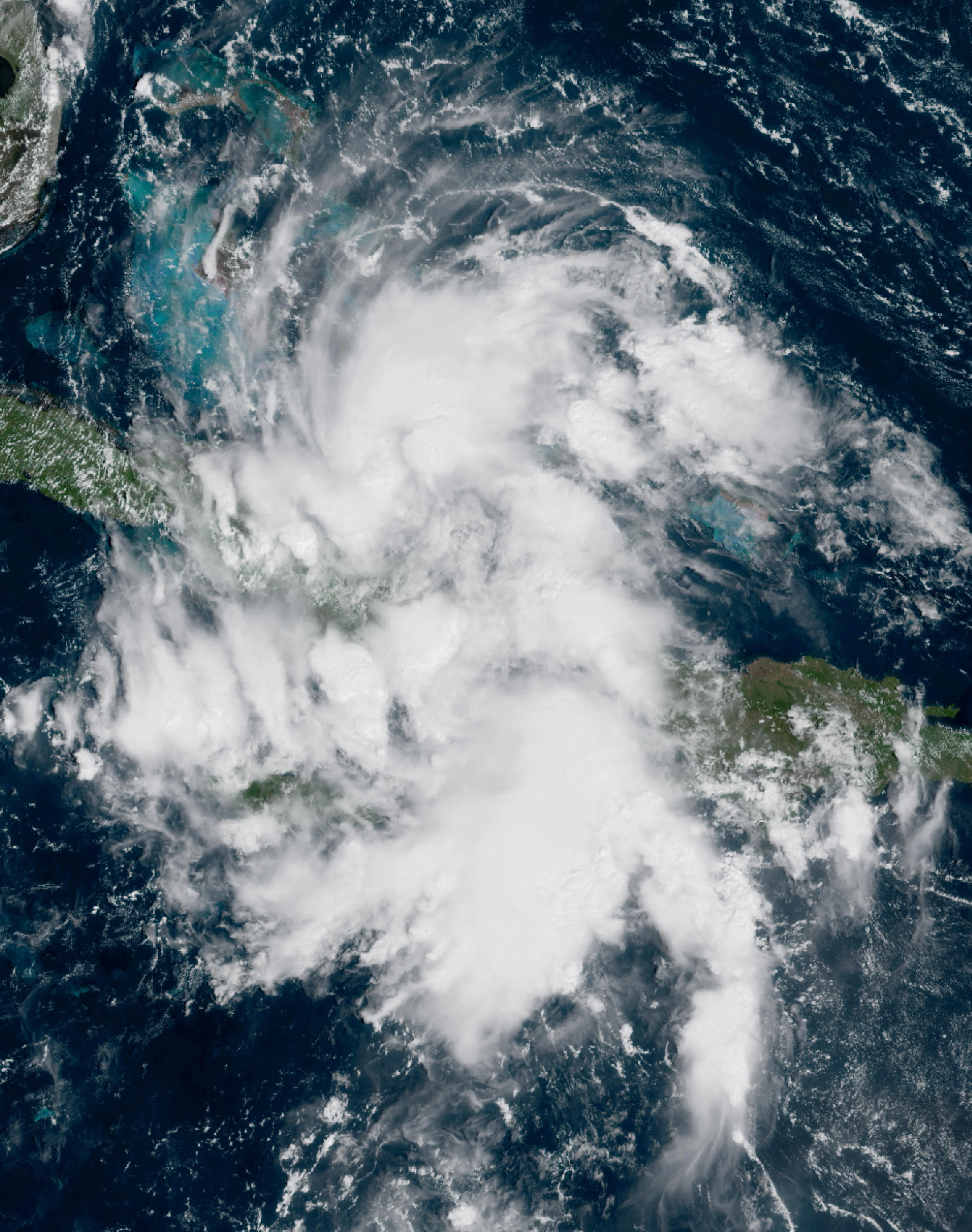 A GOES satellite image of a newly formed tropical depression with curved bands of clouds spiraling toward a center